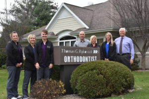 Our dental team standing by our practice sign